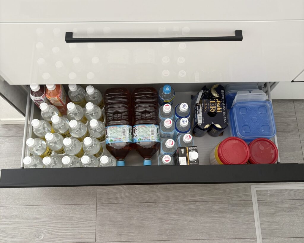 下の左の引き出し(整理後)。冷蔵庫が近いこの場所に飲み物ストックを移動した。量を減らした保存容器もここに入れた。