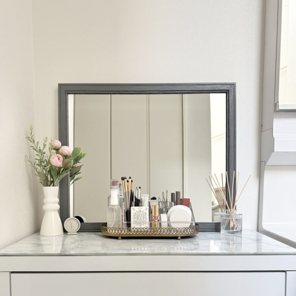 お花屋リードディフューザーが飾られ、きれいに化粧品が並んだメイクスタンドが置かれているドレッサーの写真