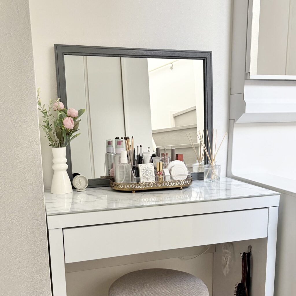 お花屋リードディフューザーが飾られ、きれいに化粧品が並んだメイクスタンドが置かれているドレッサーの写真