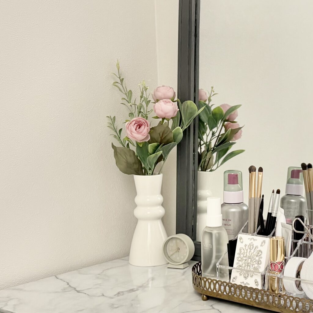 ドレッサーの上に飾られているお花と置時計の写真